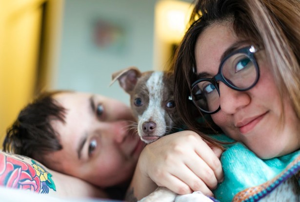 Women snuggling with child and puppy