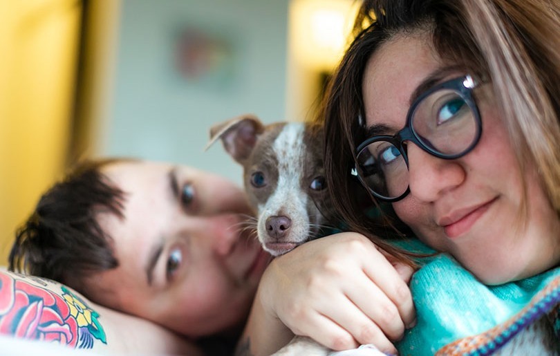 Women snuggling with child and puppy