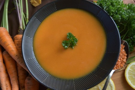 Vegetable soup in a dark bowl with vegetables