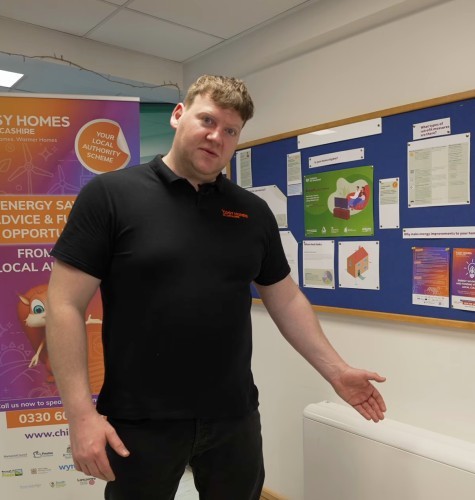 Cosy Homes in Lancashire staff stood with a high heat retention storage heater